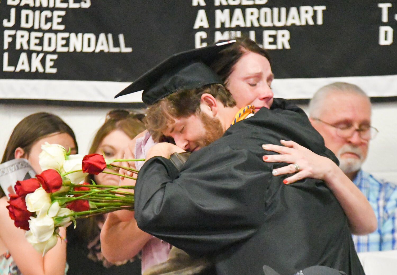 An emotional hug during graduation after a bundle of flowers was delivered to Dalton Newton’s family.