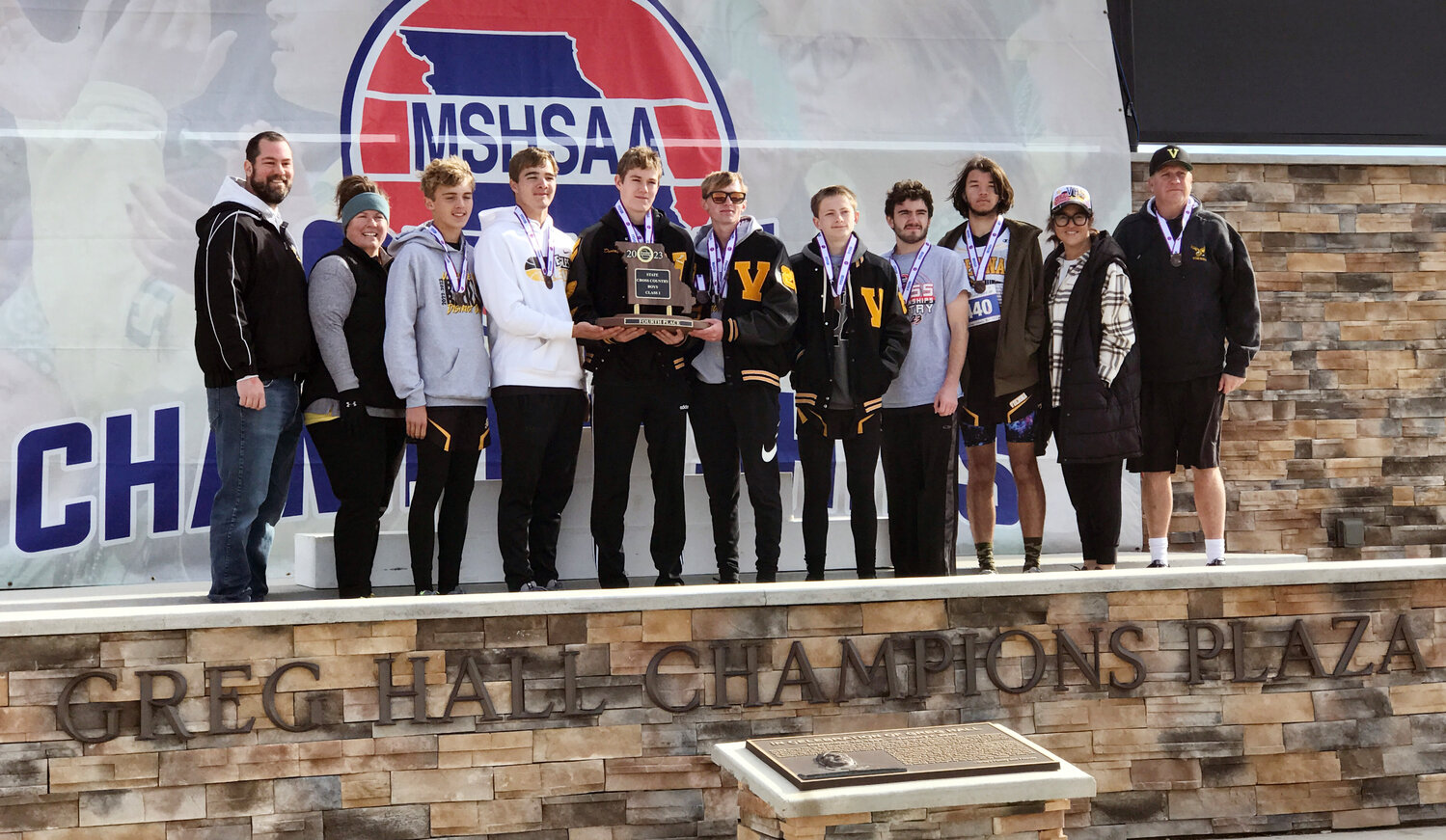 VIENNA EAGLE cross country team members and coaches proudly stand on the podium with their fourth-place trophy from the MSHSAA Cross Country Championships Friday in Columbia.